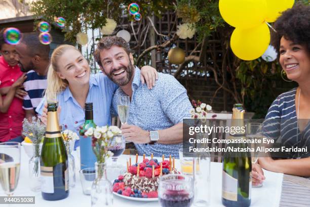 multi generation family enjoying birthday party at garden patio table - 40 birthday stock pictures, royalty-free photos & images