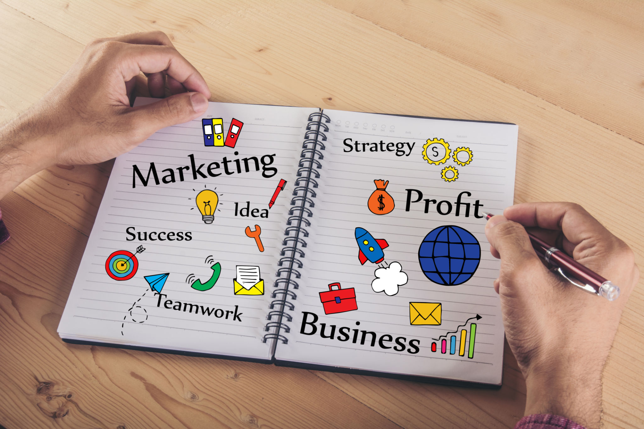 Close up of businessman hands writing on paper with business colourful doodle icon. Business concept. Close up of businessman hands writing on paper with business colourful doodle icon. Business concept.