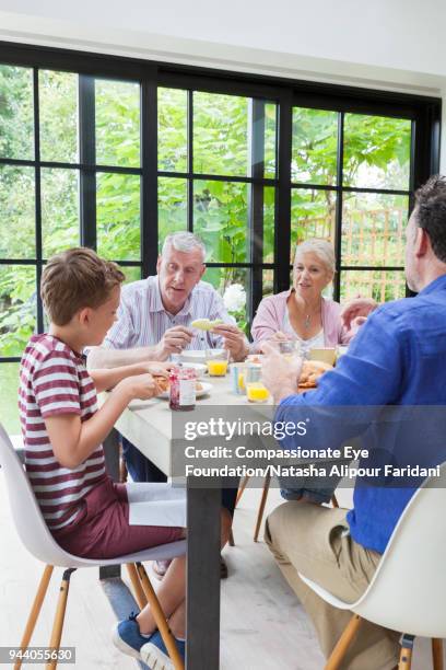 multi generation family having breakfast at dining table - pastry shoes stock pictures, royalty-free photos & images