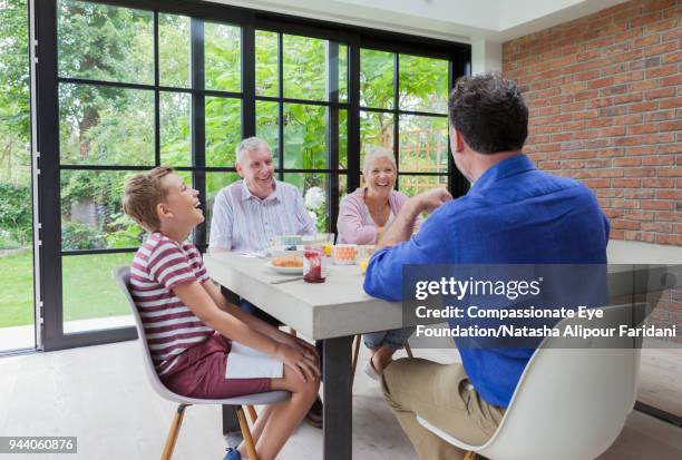 multi generation family having breakfast at dining table - pastry shoes stock pictures, royalty-free photos & images