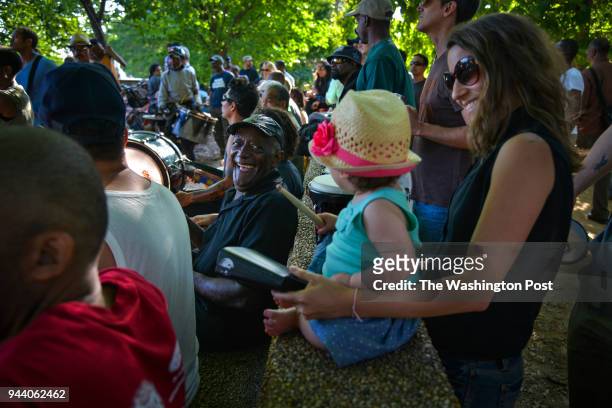 Willey Posey, C, greets Maria Leoni and her daughter Julia Beitler-Leoni during the Summer season's weekly African drum circle at Meridian Hill Park...