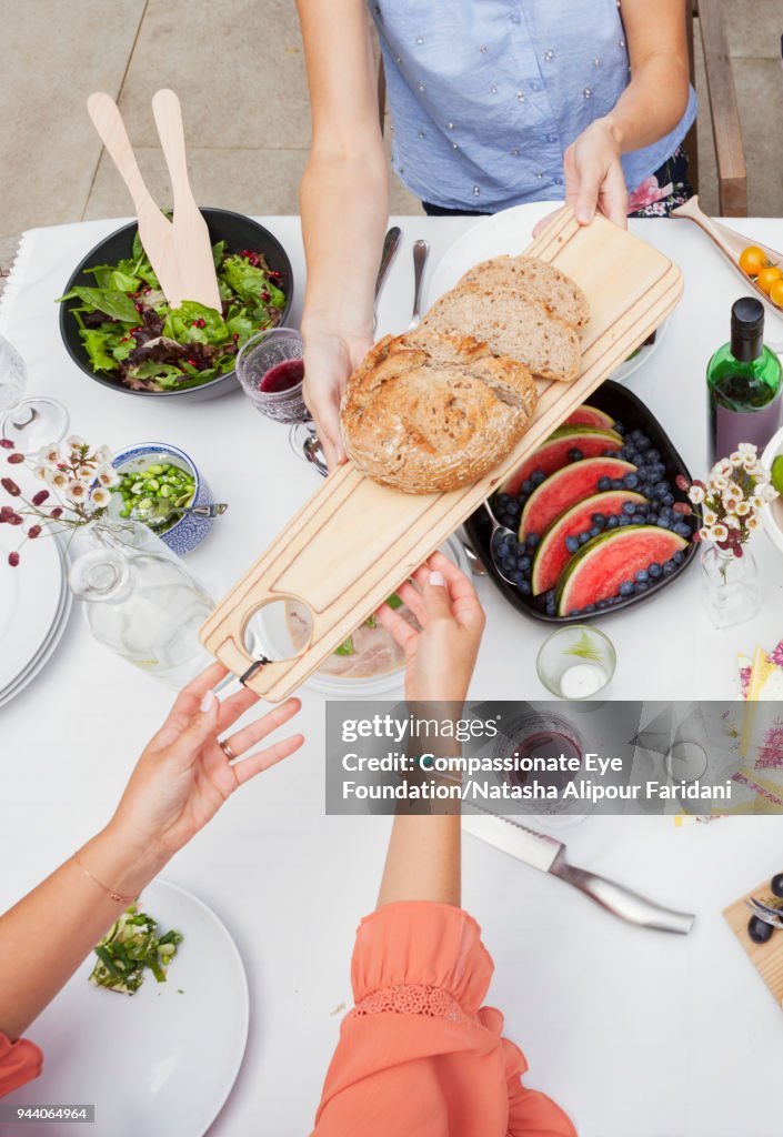 Overhead view of friends enjoying garden party lunch on patio table