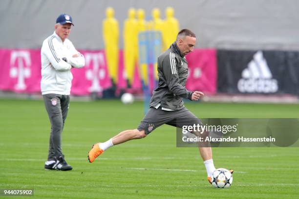 Franck Ribery of Bayern Muenchen plays with the ball as his head coach Jupp Heynckes looks on during a Bayern Muenchen training session ahead of the...