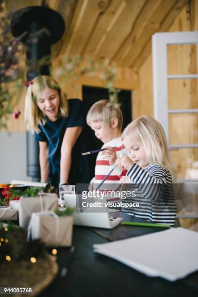 mother with two child using watercolour paints - christmas scandinavia stock pictures, royalty-free photos & images