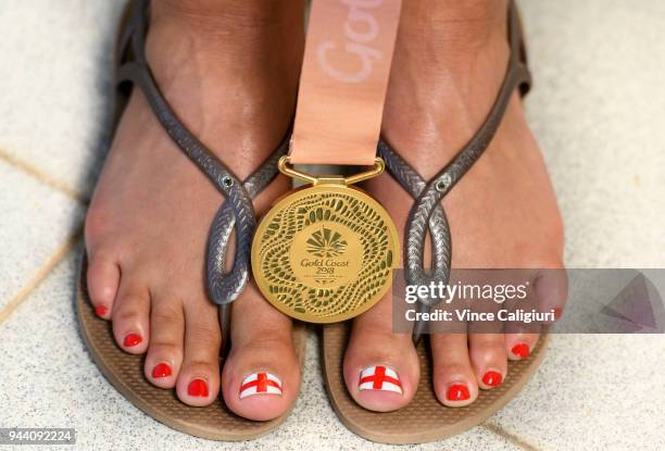 Aimee Willmott of England poses her Gold medal on her feet at team England Headquarters in Main Beach on day six of the Gold Coast 2018 Commonwealth...