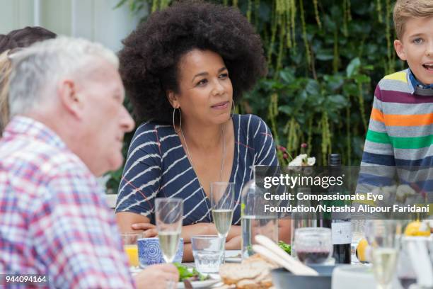 multi generation family enjoying lunch at garden patio table - charm earring stock pictures, royalty-free photos & images