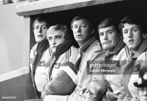 Manchester United manager Alex Ferguson sits in the dugout with coaching staff during the League Division One match against Charlton Athletic at The...