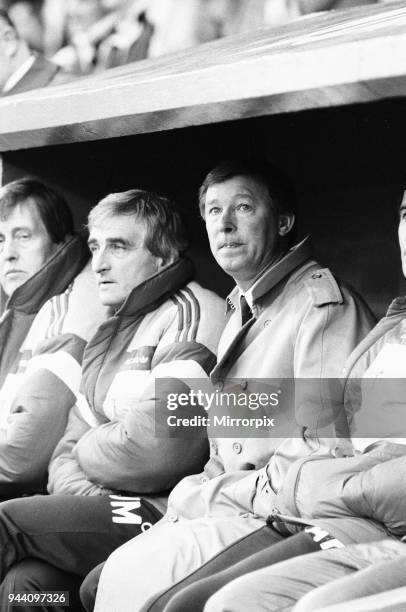 Manchester United manager Alex Ferguson sits in the dugout with coaching staff during the League Division One match against Charlton Athletic at The...