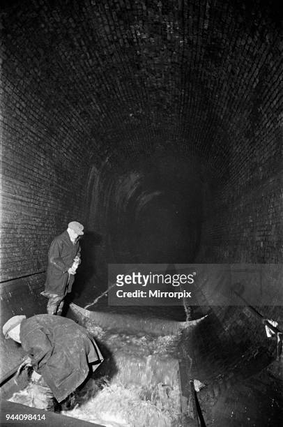 Edward Farmer and his gang seen here underground cleaning scraps of paper and anything likely to cause obstruction in the culvert under Central...