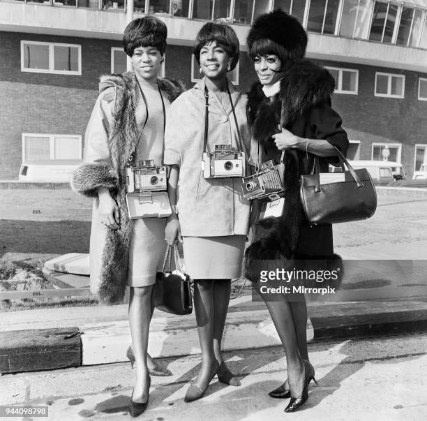 The Supremes pictured here each with a Polaroid Camera around their neck. They arrived at a London Airport from Copenhagen to appear in 'Ready Steady...