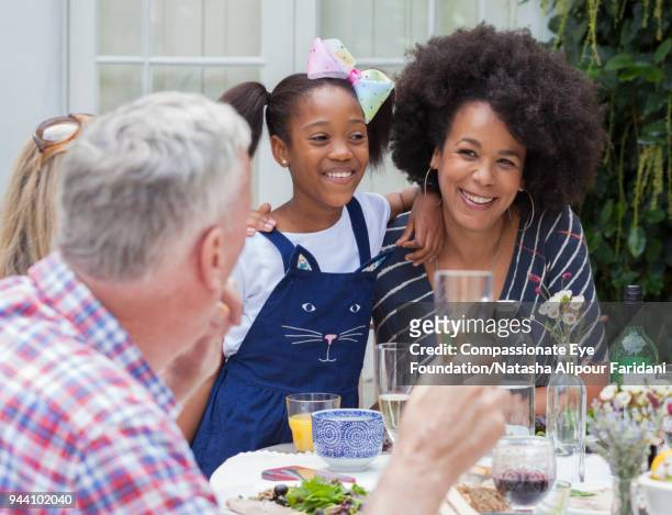 multi generation family enjoying lunch at garden patio table - charm earring stock pictures, royalty-free photos & images