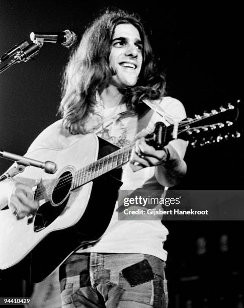 Glenn Frey of The Eagles performs on stage, playing a twelve string acoustic guitar with a capo, c 1974 in United States.