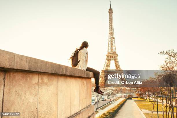 femme regardant la tour eiffel à paris - paris tour eiffel photos et images de collection