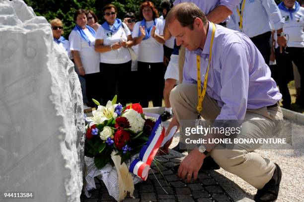 Tour de France director Christian Prudhomme lays down a bunch of flowers on a stela built in memory of Italian cyclist Fabio Casartelli in the Portet...