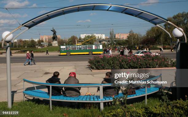 Poeple wait at a bus stop October 19, 2008 in front of the statue of Alexander Suvorov the founder of Tiraspol in the Transnistria region in Moldova....