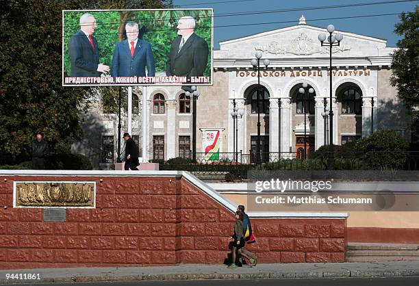 Poeple passing a billboard showing the Presidents of Transnistria, South Ossetia and Abkhazia in the center of Tiraspol in the Transnistria region in...