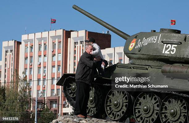 Man and his grandson are climbing on October 19, 2008 a Soviet T-34 tank, commemorating the Soviet victory in World War II in front of the...