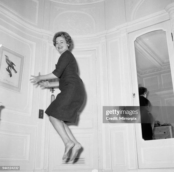 Olivia De Havilland playing a jumping game with her husband, 20th November 1959.