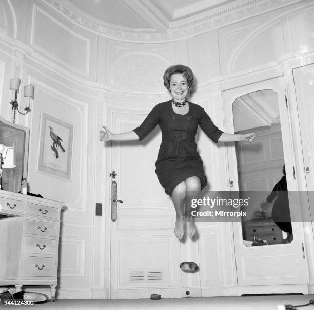 Olivia De Havilland playing a jumping game with her husband, 20th November 1959.