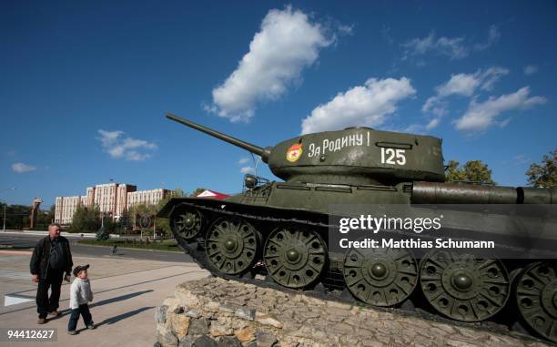 Man and his grandson pass a Soviet T-34 tank, commemorating the Soviet victory in World War II on October 19, 2008 in front of the Transnistrian...