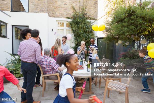 multi generation family enjoying birthday celebration lunch at garden patio table - 127th anniversary of congress party foundation day stockfoto's en -beelden