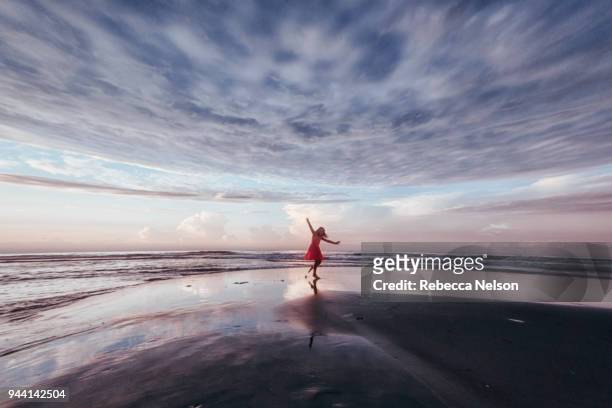 girl exploring beach at sunrise - rotation concept stock pictures, royalty-free photos & images