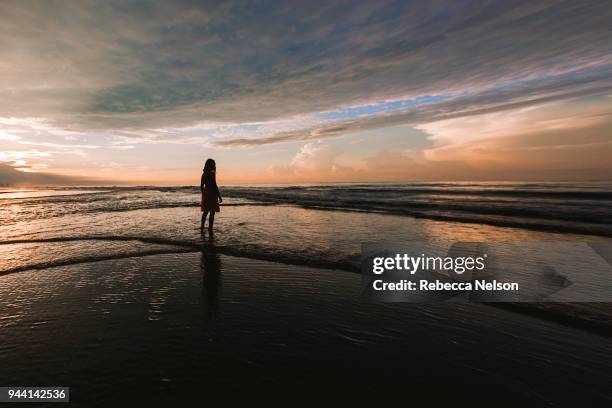 girl exploring beach at sunrise - us girls on the beach stock-fotos und bilder