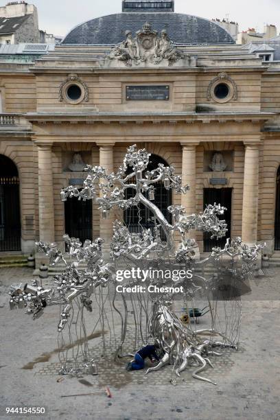 Employees install an artwork entitled 'People Tree' by Indian artist Subodh Gupta prior to the opening of his retrospective exhibition...