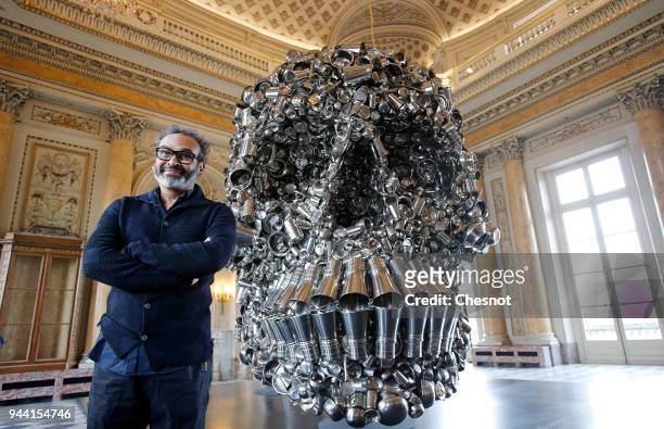 Indian contemporary artist Subodh Gupta poses in front of his artwork "Very Hungry God" prior to the opening of his retrospective exhibition...