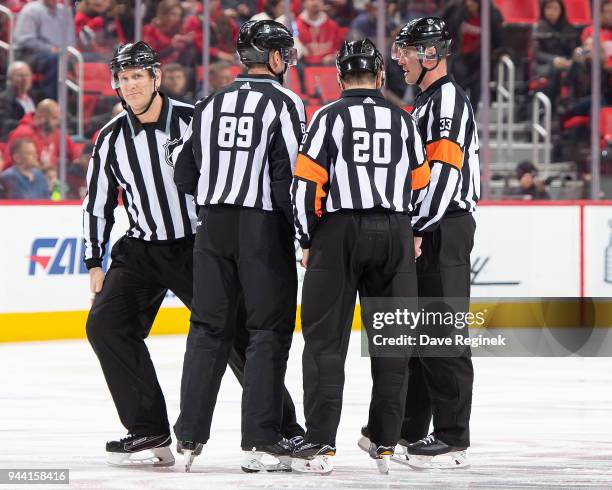 Linesmen Steve Miller and Greg Devorski along with Referee's Tim Peel and Kevin Pollock gather at center ice before the start of an NHL game between...