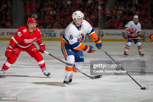 Tanner Fritz of the New York Islanders controls the puck in front of Luke Glendening of the Detroit Red Wings during an NHL game at Little Caesars...