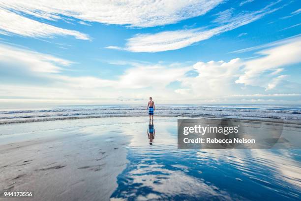 boy wading at water's edge - ankle deep in water fotografías e imágenes de stock
