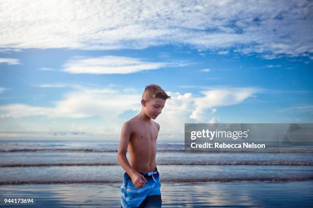 boy wading at water's edge - ankle deep in water fotografías e imágenes de stock