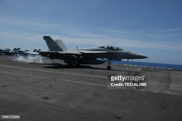 An FA-18 hornet fighter jet hits an arresting wire as it lands during a routine training aboard US aircraft carrier Theodore Roosevelt in the South...