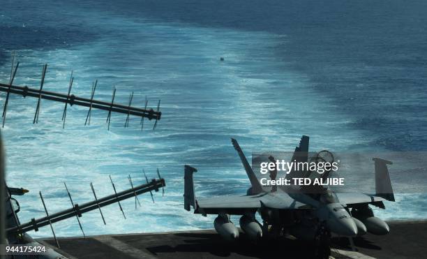 Sailor inspects atop an FA-18 hornet fighter jet during a routine training aboard US aircraft carrier Theodore Roosevelt in the South China sea on...