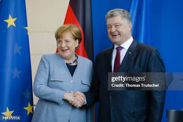 German Chancellor Angela Merkel and Ukrainian President Petro Poroshenko shake hands after their meeting in the German chancellery on April 10, 2018...