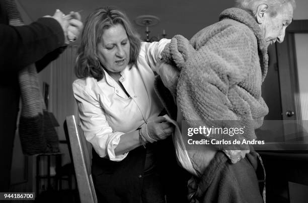 Maria Del Palacio is seen being helped by a social assitsant on December 7, 2016 in Madrid, Spain. Maria del Palacio, a ninety-five year old widow,...