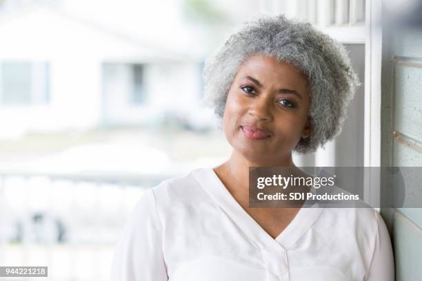 senior woman stands proudly outside her home - cabeça inclinada imagens e fotografias de stock