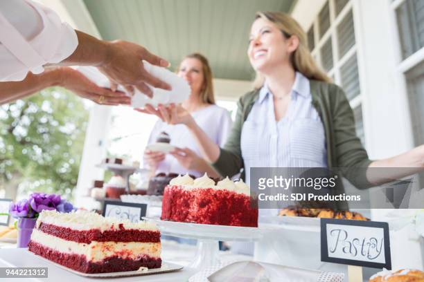 women volunteer at cancer awareness event - bake sale stock pictures, royalty-free photos & images