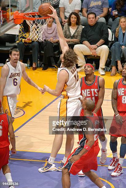 Pau Gasol of the Los Angeles Lakers dunks the ball against Sean Williams and Bobby Simmons of the New Jersey Nets during the game on November 29,...