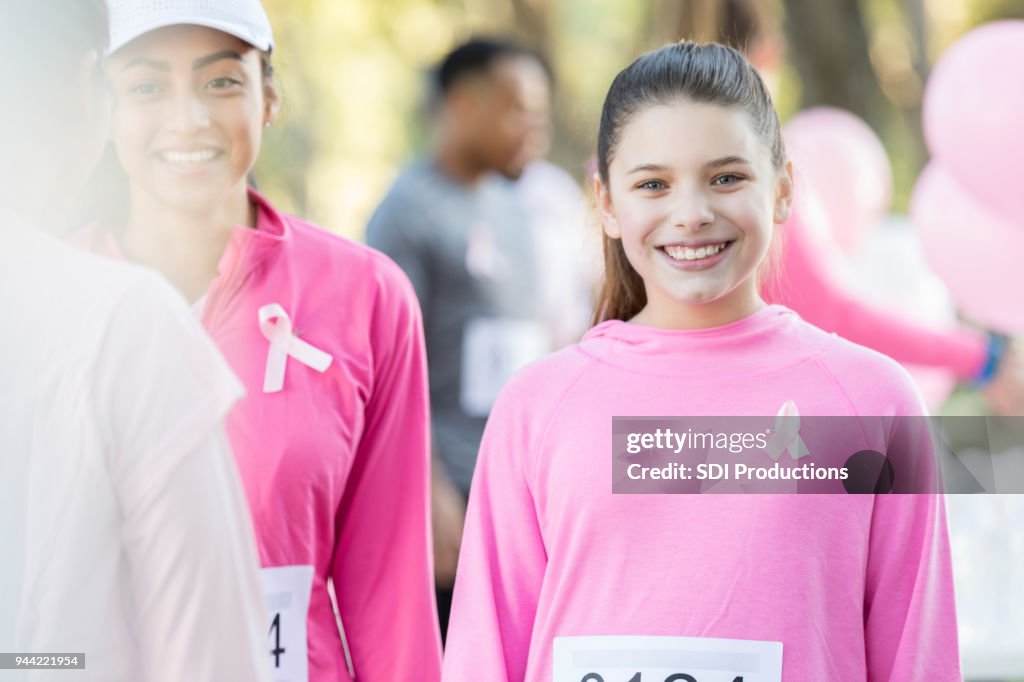 Cheerful teenager prepares to run in breast cancer awareness race