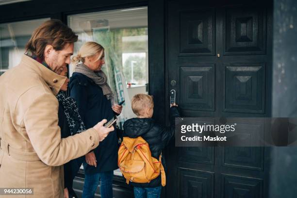rear view of unlocking combination lock on house door by family - open day 14 stock pictures, royalty-free photos & images