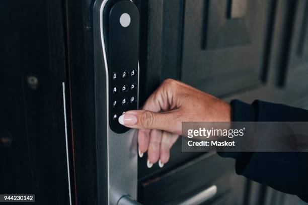 cropped hand of woman unlocking combination security code on house door - código de segurança - fotografias e filmes do acervo