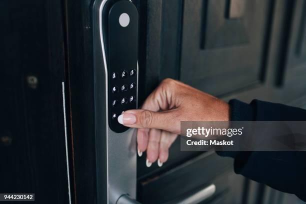 cropped hand of woman unlocking combination security code on house door - säkerhetskod bildbanksfoton och bilder