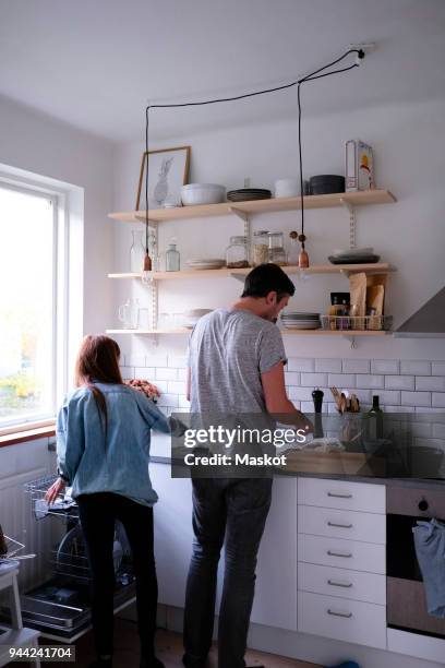 rear view of man and woman working in kitchen at home - tool rack ストックフォトと画像