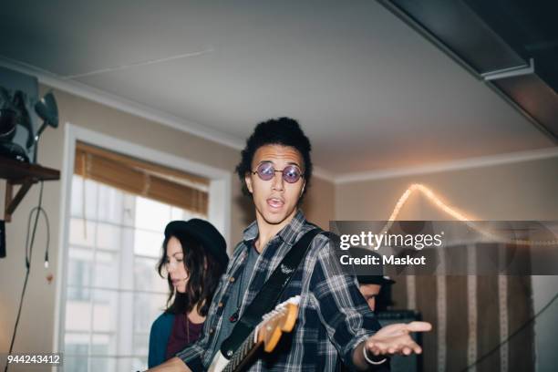 male musician singing while playing instruments with friends at studio - play rehearsal stock pictures, royalty-free photos & images