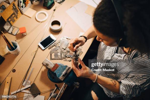 high angle view of technician working on equipment at desk in workshop - inventor fotografías e imágenes de stock