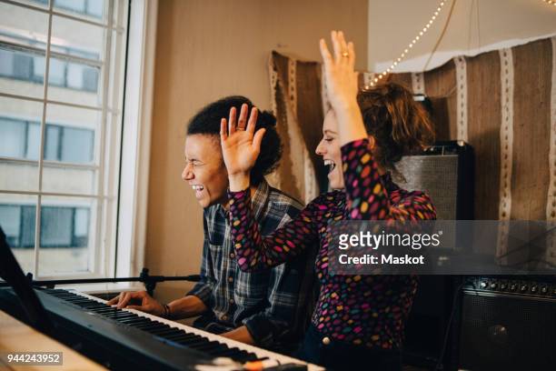 happy friends enjoying while playing piano and practicing at recording studio - music stock-fotos und bilder
