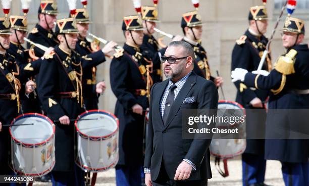 Morocco's King Mohammed VI walks past the honor guard as he arrives for a meeting with French President Emmanuel Macron at the Elysee Presidential...