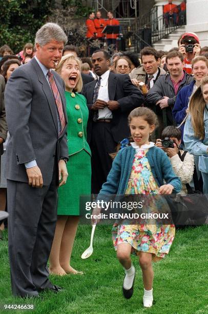 First Lady Hillary Clinton reacts as US President Bill Clinton blows a whistle to officially signal the start 12 April 1993 of annual White House...